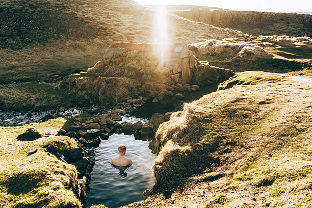 Man in the hot spring Man swimming in the hot spring in Iceland thermal pool stock pictures, royalty-free photos & images