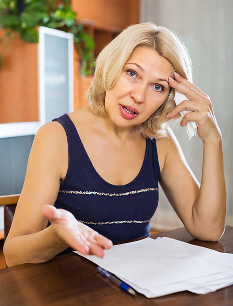 istock Sad woman filling financial documents 530413499