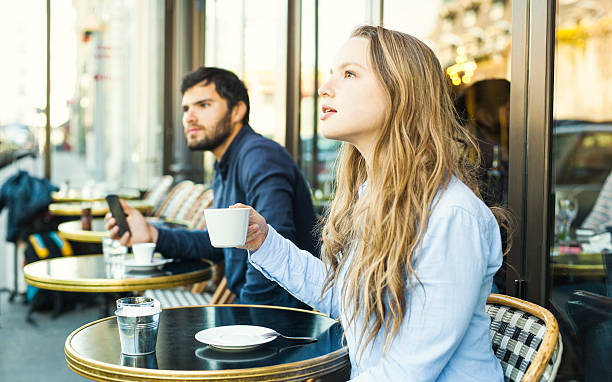 istock Woman Enjoying Coffee in a Cafe Next to a Stranger 530413840
