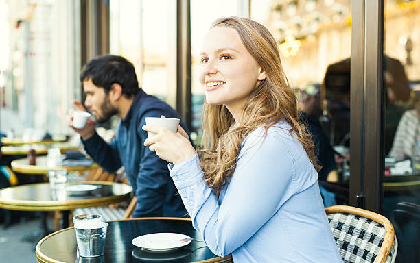 Young Lovely Woman Having Coffee Break in a Sidewalk Cafeteria