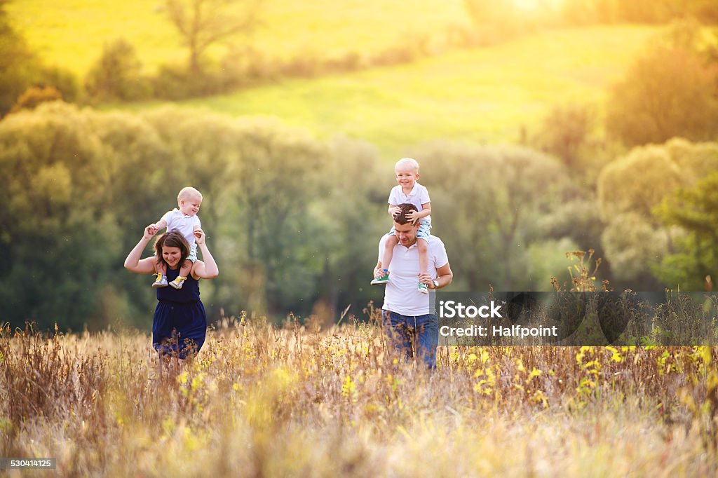 Family enjoying life together outside Happy family enjoying life together at meadow outdoor. Adult Stock Photo