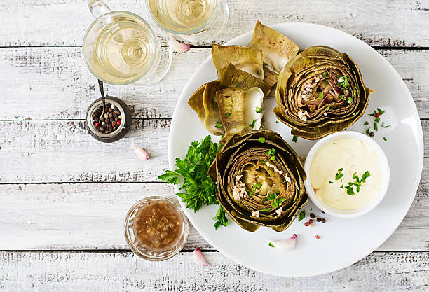 Baked artichokes cooked with garlic sauce, mustard and parsley Baked artichokes cooked with garlic sauce, mustard and parsley. Top view artichoke stock pictures, royalty-free photos & images
