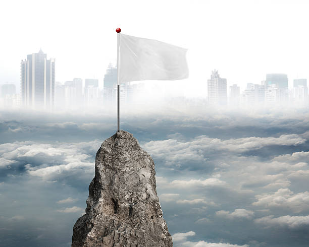 istock blank white flag on mountain peak with cloudy sky cityscape 530414653