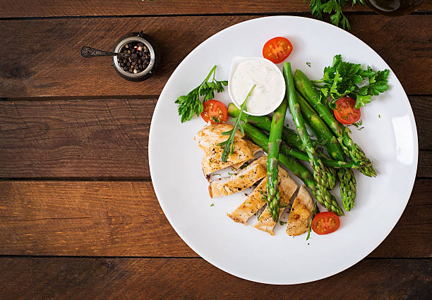 istock Baked chicken garnished with asparagus and herbs 530415158