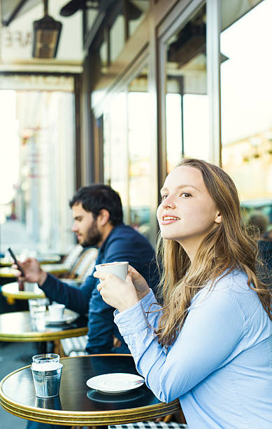 istock Young Woman Watching People from a Sidewalk Cafeteria 530415224