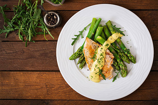 Baked chicken garnished with asparagus and herbs Baked chicken garnished with asparagus and herbs. Top view main course stock pictures, royalty-free photos & images