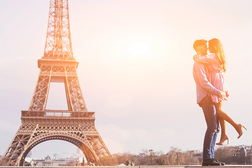 love in the most romantic city - Paris, young couple at Eiffel Tower and vanilla sky