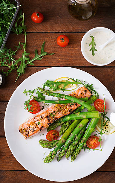 istock Baked salmon garnished with asparagus and tomatoes with herbs 530417836