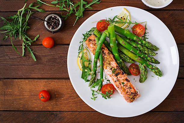 salmão assado servido com aspargos e tomate com ervas - gourmet salad dinner prepared fish - fotografias e filmes do acervo