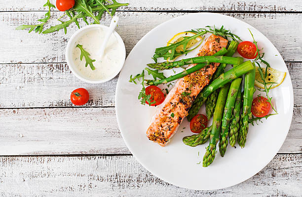 istock Baked salmon garnished with asparagus and tomatoes with herbs 530418146