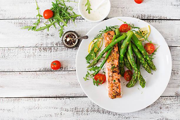istock Baked salmon garnished with asparagus and tomatoes with herbs 530418242