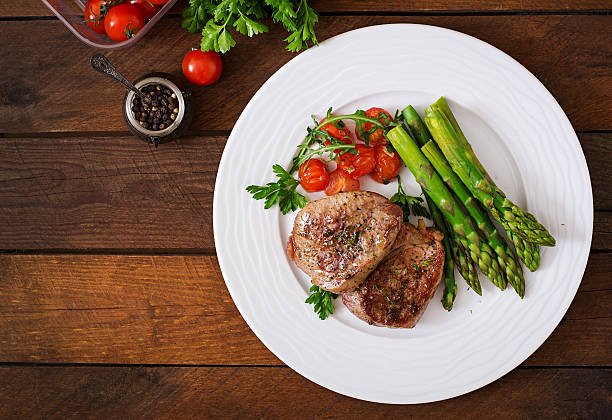 bistecs de carne de res asado a la parrilla con espárragos y tomates. - plato principal fotografías e imágenes de stock