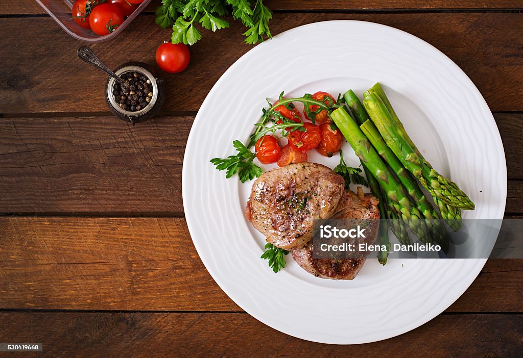 Barbecue carne Bistecca di manzo alla griglia con asparagi e pomodorini. - Foto stock royalty-free di Piatto - Stoviglie