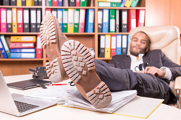 устали африканских человек в офисе сна - men sleeping african descent shoe стоковые фото и изображения