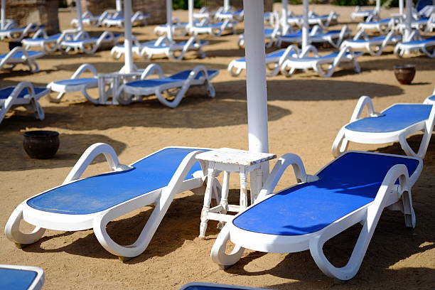 istock Blue beach chairs and sun umbrella on sand 530420878