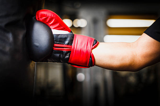 istock Punching a punching bag with red boxing gloves 530421400