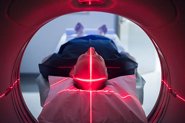 paciente de sexo masculino en equipo médico de escaneo con luces roja - cat scan mri scanner healthcare and medicine medical exam fotografías e imágenes de stock