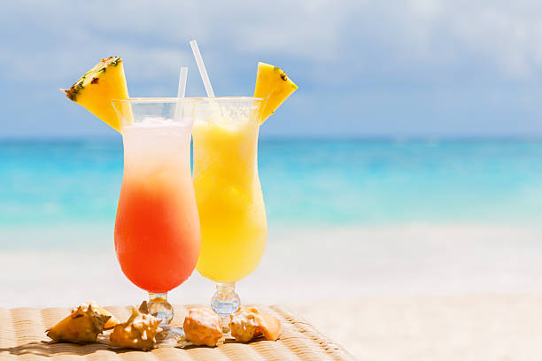 Two tropical fresh juices on white sandy beach stock photo