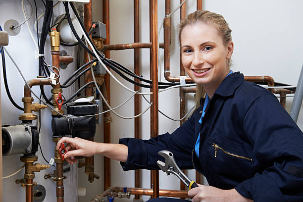 Female Plumber Working On Central Heating Boiler Female Plumber Working On Central Heating Boiler adjustable wrench photos stock pictures, royalty-free photos & images