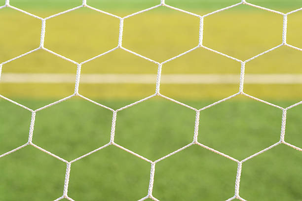 istock soccer goal net with green field background. 530424232