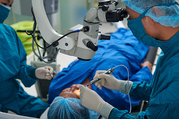 Performing surgery Doctor performing eye surgery in modern clinic operating stock pictures, royalty-free photos & images