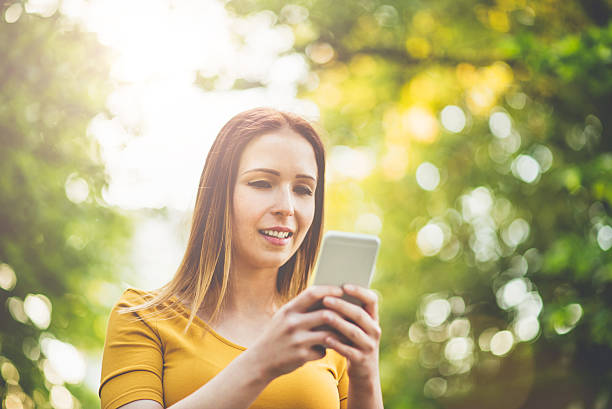 istock young woman with smart phone in summer 530424730