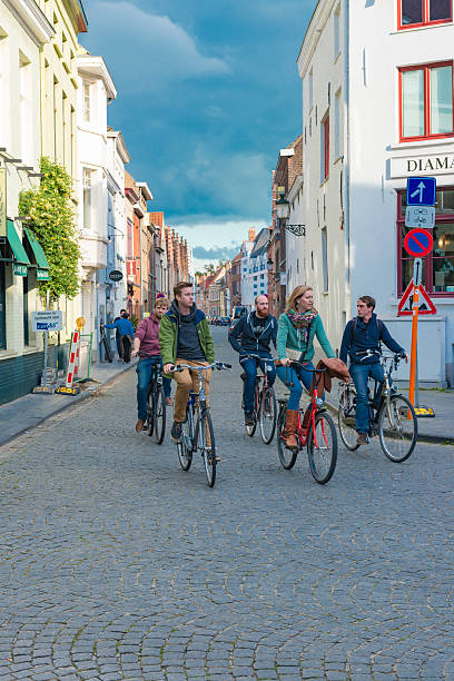 Bruges, Belgium - September 26, 2015: People walking and driving a bicycle at a street of Bruges.