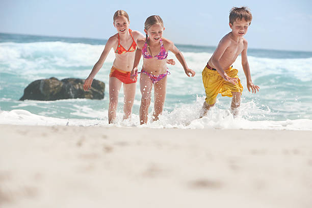 istock Cheerful Siblings Running In Water 530425385