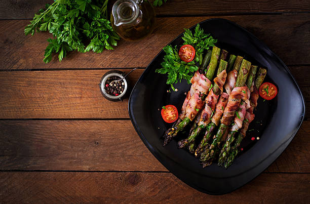 Grilled violet asparagus wrapped with bacon Grilled violet asparagus wrapped with bacon. Top view bacon wrapped stock pictures, royalty-free photos & images