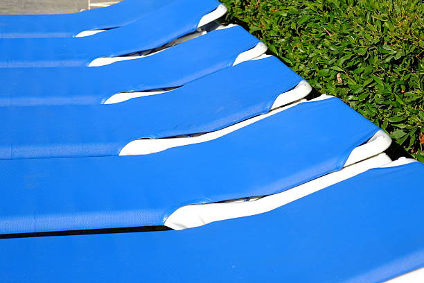 Blue beach chairs and sun umbrella near pool. Travel background.