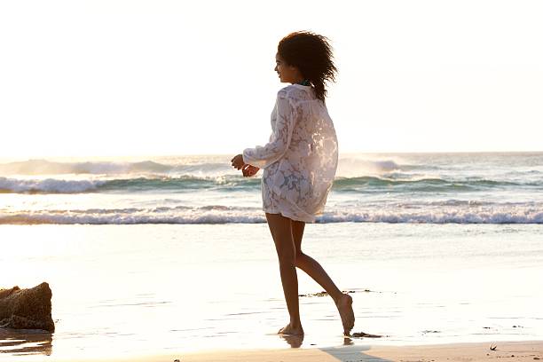 istock Attractive young woman walking on the beach barefoot 530427352