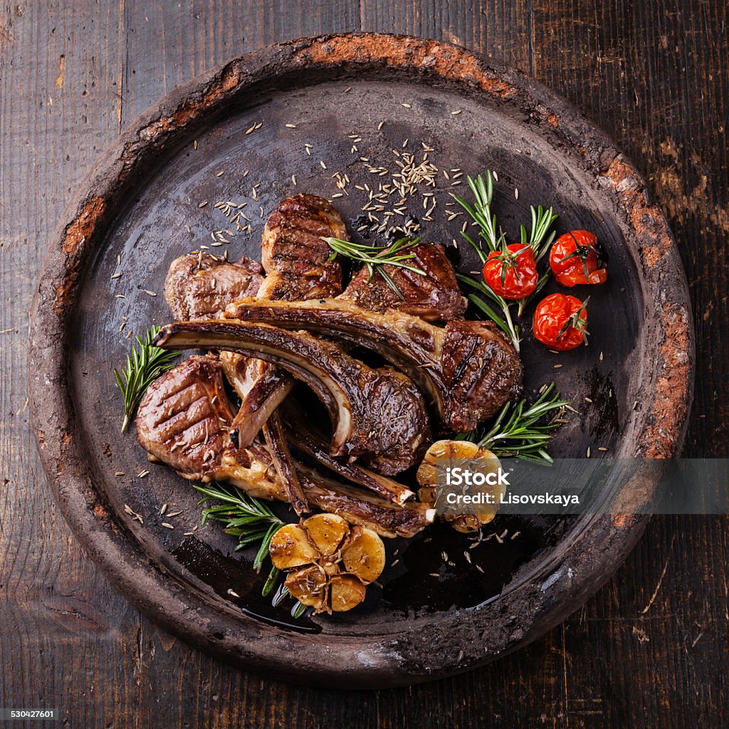 Roasted lamb ribs with spices and garlic Roasted lamb ribs with spices and garlic on dark textural background Animal Bone Stock Photo