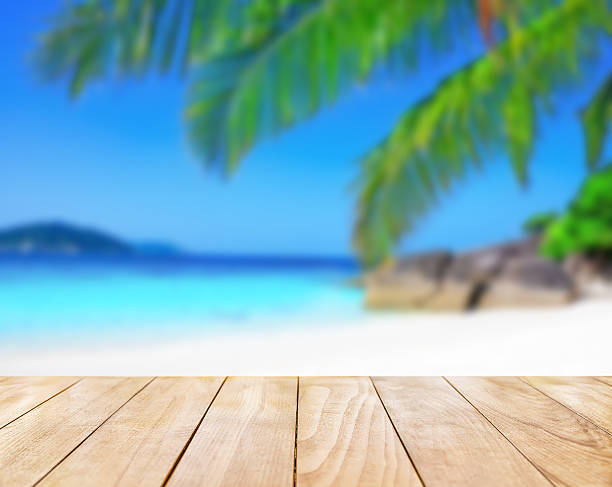 istock Wooden table top on blue sea and white sand beach 530427694