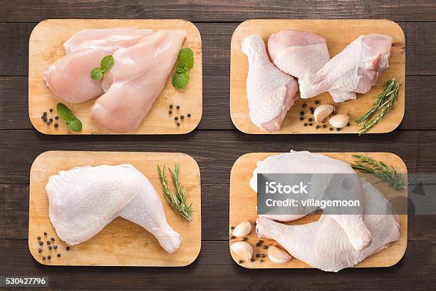 Set Raw Chicken On Cutting Board On The Wooden Background Stock Photo - Download Image Now