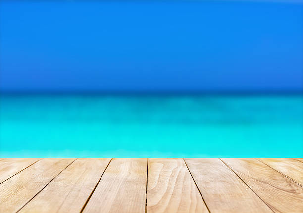 istock Wooden table top on blue sea and white sand beach 530427808