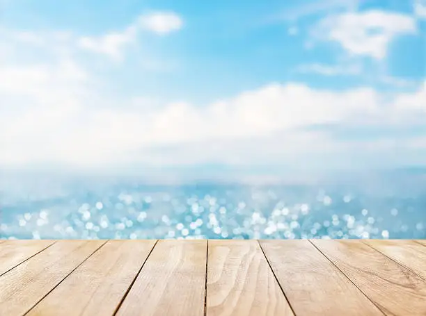 Photo of Wooden table top on blue sea and white sand beach