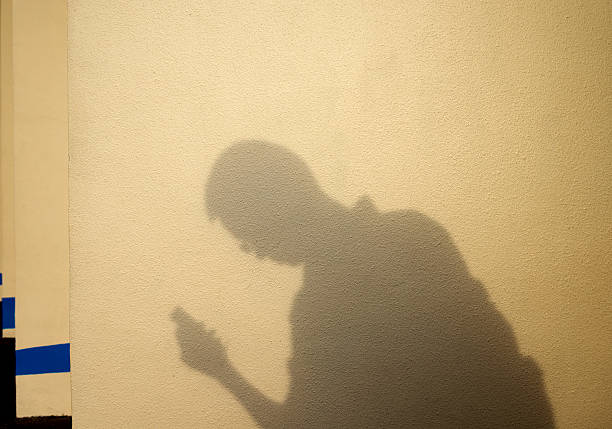 istock Shadow of man holding a phone 530430184