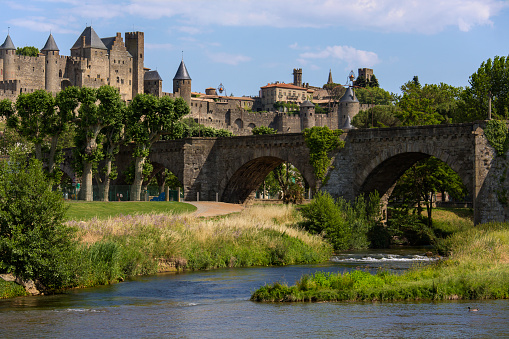 The medieval fortress and walled city of Carcassonne in south west France. Founded by the Visigoths in the fith century, it was restored in 1853 and is now a UNESCO World Heritage Site. Viewed over the Pont Vieux crossing the Aude River.