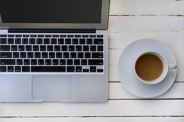 istock cup of coffee and laptop on wooden table 530433343