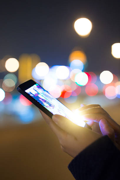 istock Woman using mobile phone at night street 530434600