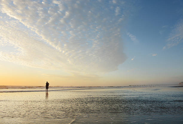 istock Man walking on the beach at sunrise. 530437552