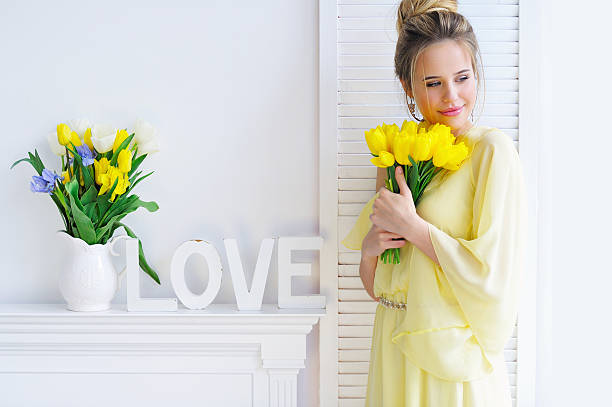 istock Gorgeous young woman with yellow tulips 530437826