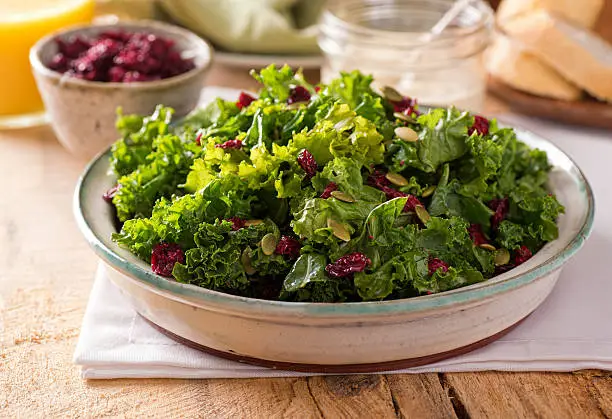 A delicious kale salad with dried cranberry and pumpkin seed.