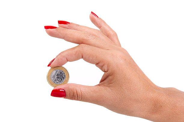 istock Woman's hand holding a Brazilian coin 530438584