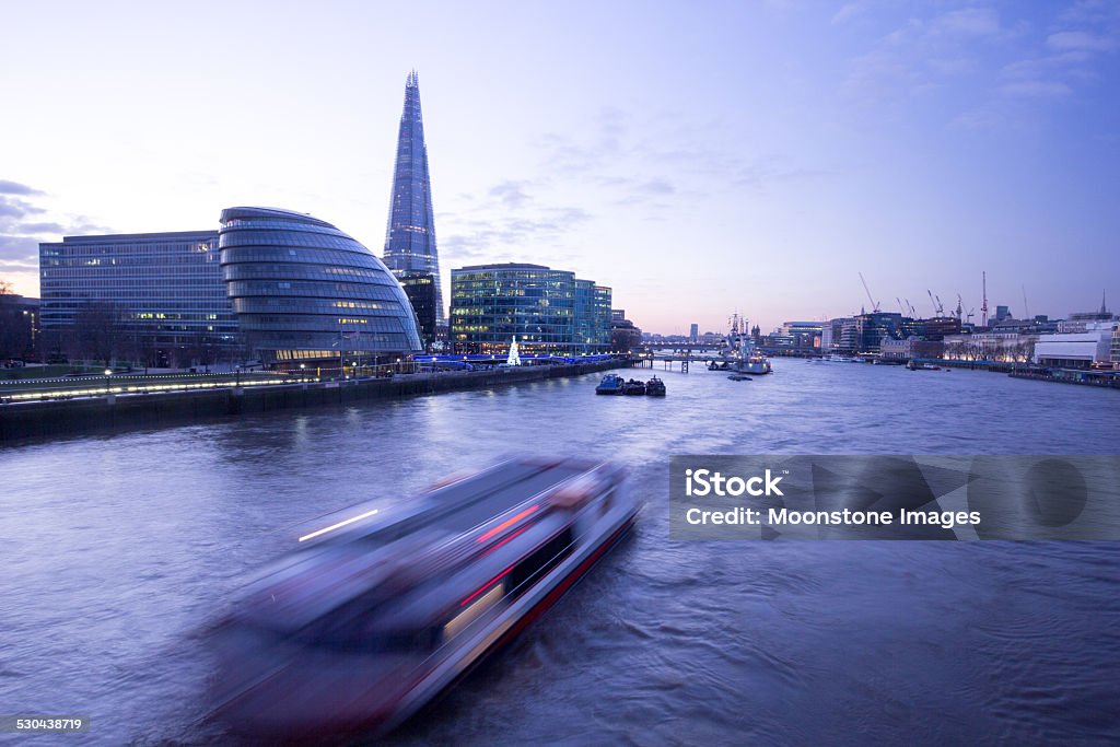 River Thames in London, England Dusk falls on the tallest office building in Europe, the Shard. Started in March 2009, this office building - the work of Renzo Piano - is located near London Bridge. It is the tallest building in the EU and was completed in March 2012. In the foreground, a water taxi or ferry passes through. Architectural Feature Stock Photo