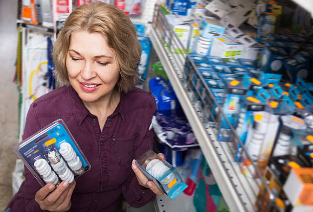 istock Elderly woman buys light bulbs at the store 530439106