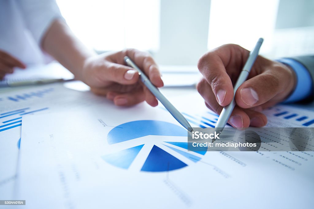 Market research Hands of business people pointing at market research Pie Chart Stock Photo