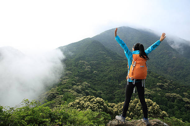 istock cheering woman hiker open arms on mountain peak 530442124
