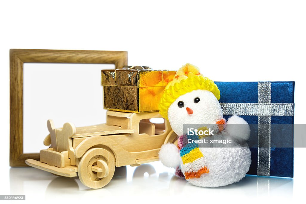 Snowman with car, gift boxes and frame Christmas snowman toy and old vintage wooden automobile with golden or yellow and blue gift boxes and wooden frame Car Stock Photo