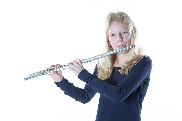 istock young blond girl playing flute in studio 530449347